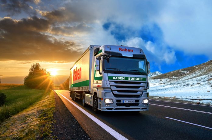 Truck driving on the asphalt road in rural landscape at sunset w Marka Godna