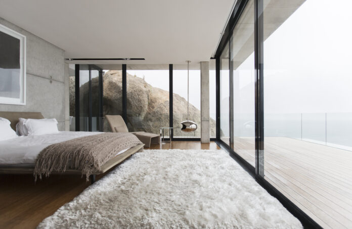 Shag rug and glass walls in modern bedroom drzwi narożne